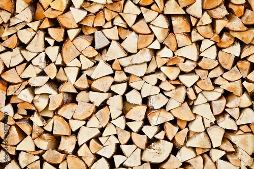 Stacked firewood close-up. Firewood storage close up. Stocks of wooden logs close-up. Chopping wood. Logging in the village. Rustic lifestyle. Woodpile with firewood full frame image. Wooden texture.