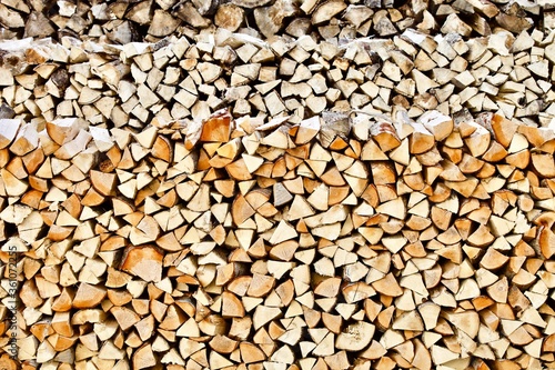 Stacked firewood close-up. Firewood storage close up. Stocks of wooden logs close-up. Chopping wood. Logging in the village. Rustic lifestyle. Woodpile with firewood full frame image. Wooden texture.