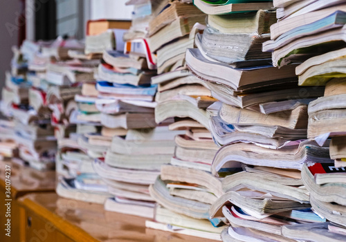 Old school education textbooks lay on a shelf inside a college creating a nice perspective. Narrow depth of field image, focus centred on closer books.