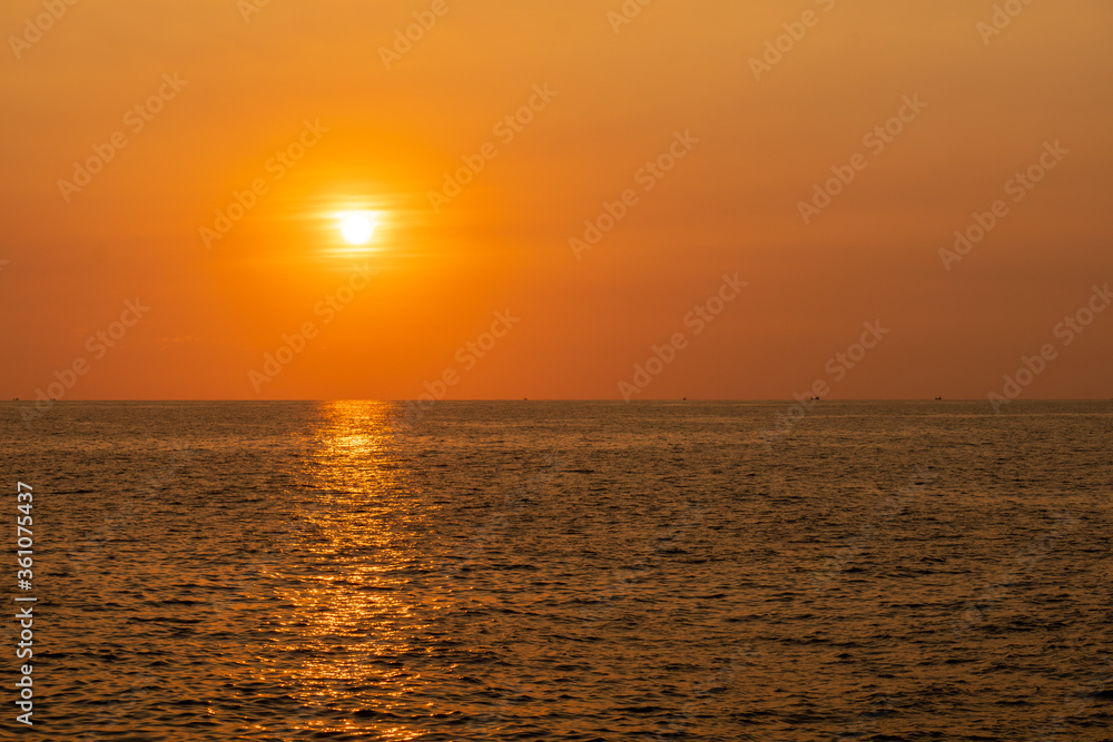 Fishing boat sails along the sea in the evening before sunset. Silhouette view