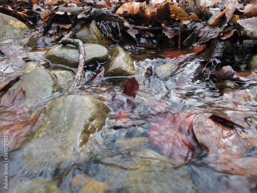 Detail of a shallow mountain stream, water flowing over rocks.
