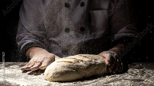 Man preparing bread dough on wooden table in a bakery close up. Preparation of Easter bread.Men hands.