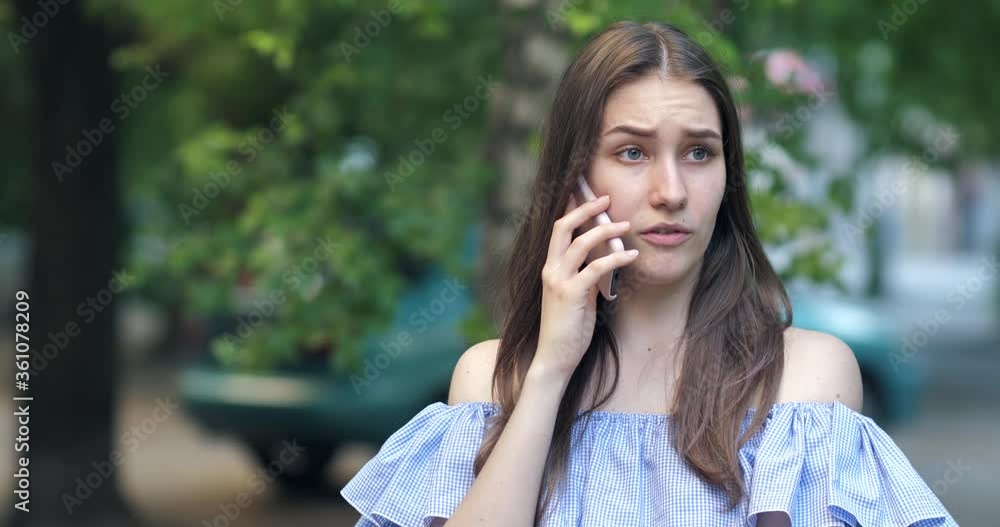 Portrait of a young woman talking on the phone. the girl grimaces, smiles Portrait of a young woman talking on the phone. the girl grimaces, smiles