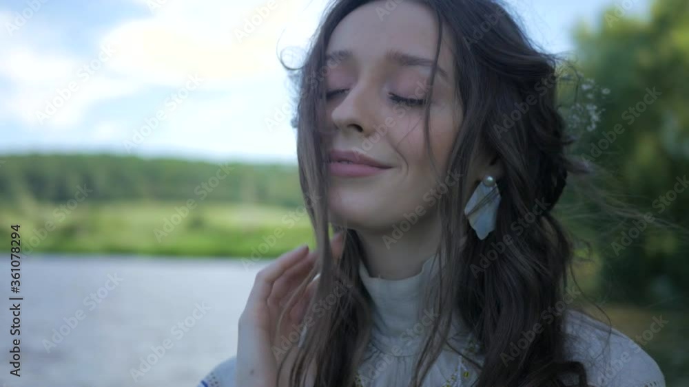 A girl dressed in an old dress stands on the river bank. Beautiful woman standing near a willow tree. Young girl walks in nature alone. Summer nature. A girl dressed in an old dress stands on the river bank. Beautiful woman standing near a willow tree. Young girl walks in nature alone. Summer nature.