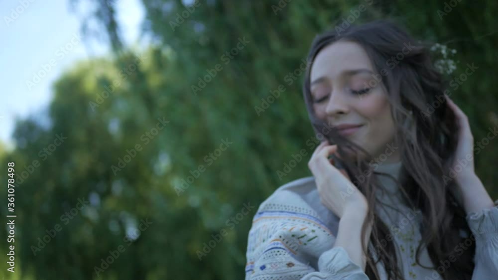 A girl dressed in an old dress stands on the river bank. Beautiful woman standing near a willow tree. Young girl walks in nature alone. Summer nature. A girl dressed in an old dress stands on the river bank. Beautiful woman standing near a willow tree. Young girl walks in nature alone. Summer nature.