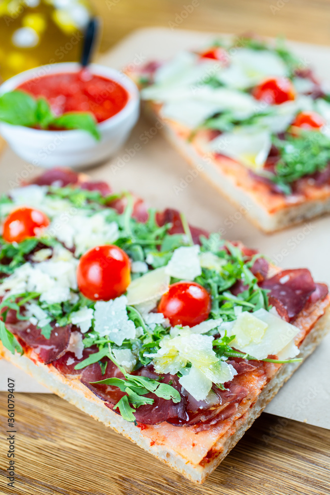 pizza with cherry tomatoes, parmesan cheese, arugula and smoked ham pizza with cherry tomatoes, parmesan cheese, arugula and smoked ham