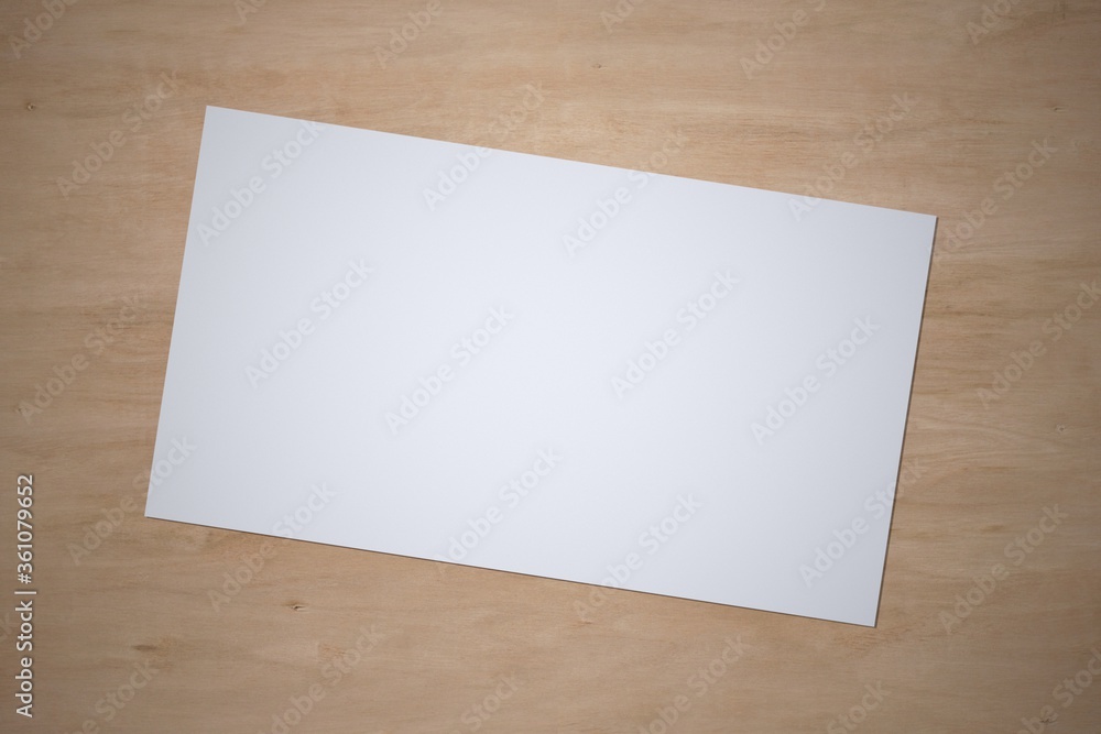 White paper sheet on wooden background. Template of A4 document and blank space for text. White paper sheet on wooden background. Template of A4 document and blank space for text.