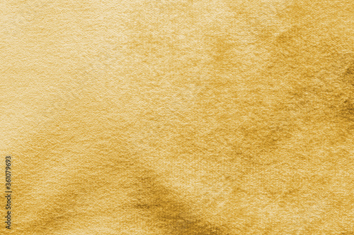 Gold velvet background or golden yellow velour flannel texture made of cotton or wool with soft fluffy velvety satin fabric cloth metallic color material
