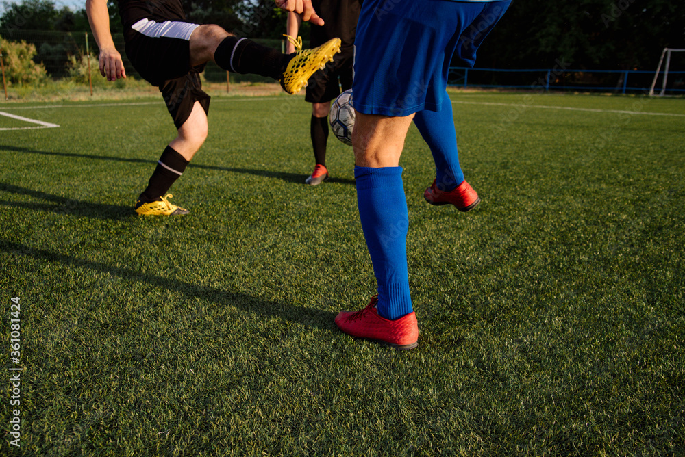 Fototapeta premium Soccer players play football on soccer field