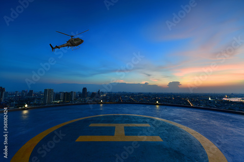 Quadro su tela Helicopter parking landing on the roof of a skyscraper with cityscape view at su