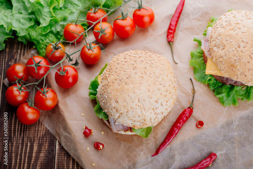 View of fresh tasty burger on wooden table. Food background.