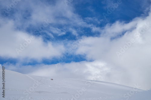 Image of a snow covered mountain plateau. Tourists walk and take pictures on a mountain plateau.