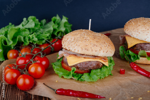 View of fresh tasty burger on wooden table. Food background.