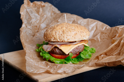 View of fresh tasty burger on wooden table. Food background.