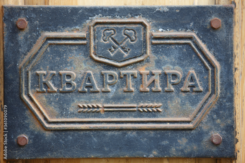 close up filled frame shot of a beautiful old weathered vintage retro blue metal door sign plate saying in Cyrillic Russian APARTMENT close up filled frame shot of a beautiful old weathered vintage retro blue metal door sign plate saying in Cyrillic Russian APARTMENT