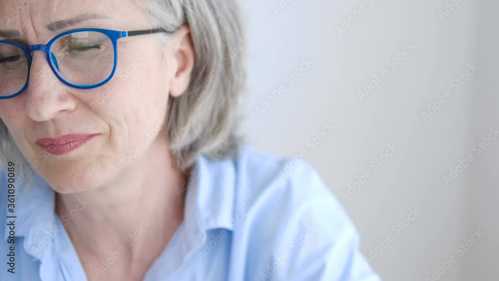 Pretty mature woman feeling pain in her neck, consequences of overworking Pretty mature woman feeling pain in her neck, consequences of overworking