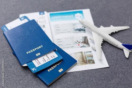 White blank model of passenger plane on passports with boarding pass on blue rustic wooden background photo