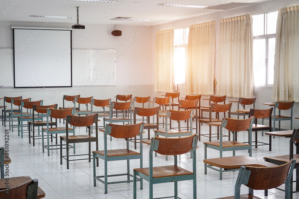 Empty classroom with vintage tone wooden chairs. Classroom arrangement in social distancing concept to prevent COVID-19 pandemic. Back to school concept.	