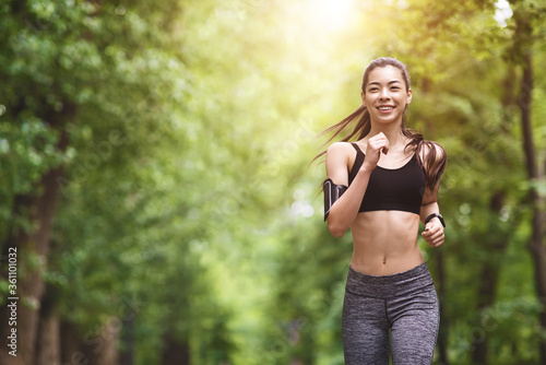 Fototapeta Naklejka Na Ścianę i Meble -  Healthy Lifestyle. Sporty Asian Girl In Jogging In City Park