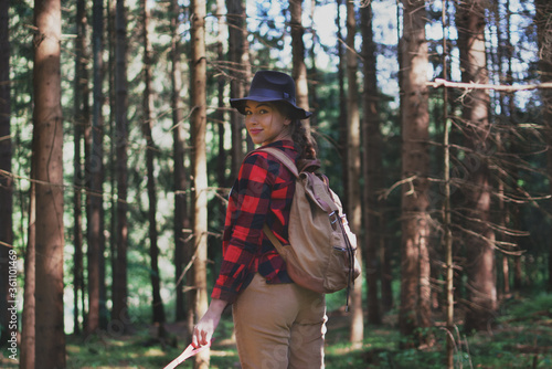 Young woman on a walk outdoors in forest in summer nature.