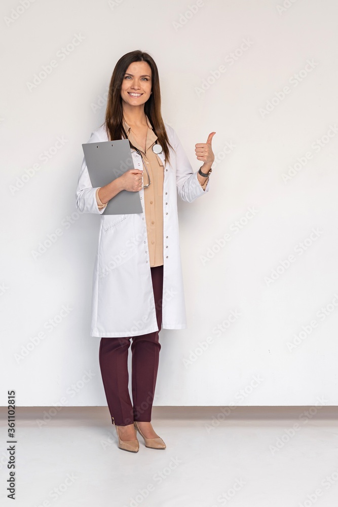 Friendly female doctor with thumbs up - isolated over white. Friendly female doctor with thumbs up - isolated over white.