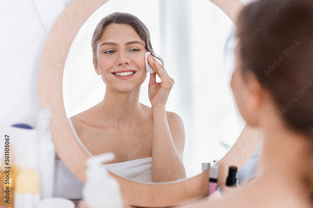 Fresh looking girl using cotton pad, cleamsing morning procedures Fresh looking girl using cotton pad, cleamsing morning procedures