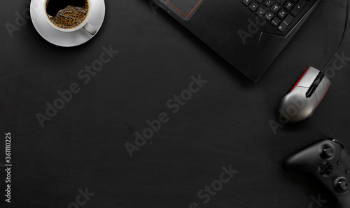 Φωτογραφία top view of gamer desk workspace with coffee cup and laptop on black table background