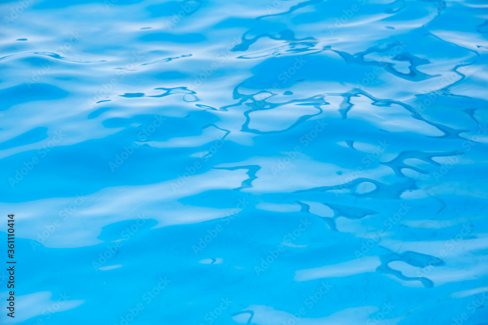 Repeating summer pattern of photographed, living water surfaces in a pool, with the emphasis on light refraction where you can see the sprinkled ground moving along with the waves