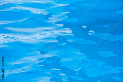 Repeating summer pattern of photographed, living water surfaces in a pool, with the emphasis on light refraction where you can see the sprinkled ground moving along with the waves