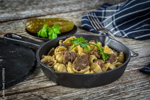 Italian pasta shells with beef sauce in cast iron pan.