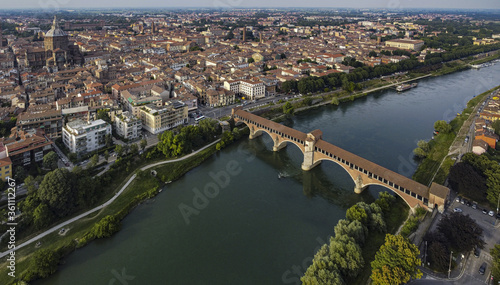 Classic aerial view of Pavia, Italy, in the afternoon: the dome and the old bridge on Ticino river