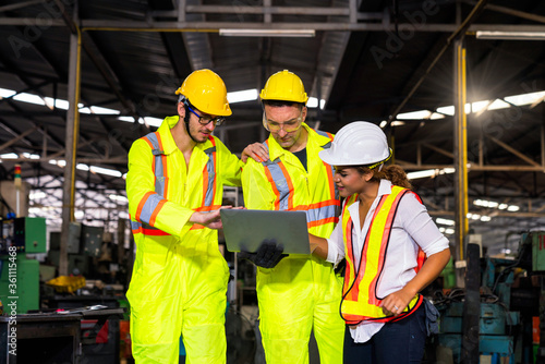 Engineers and skilled technicians are holding laptops and working in industrial plants.