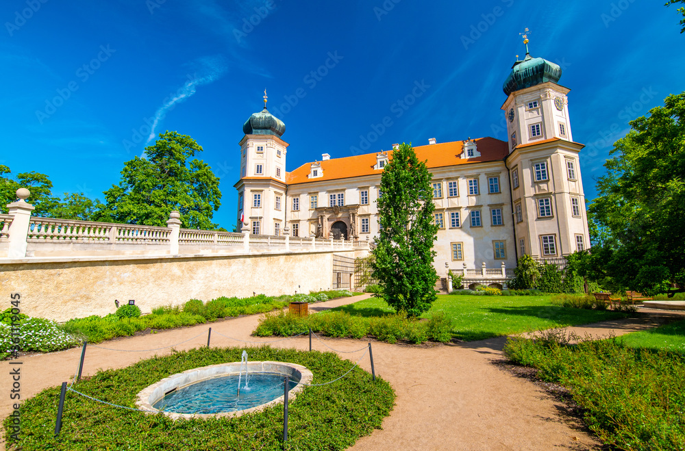 Historical chateau at Mnisek pod Brdy city, Czech Republic. View of ancient building with towers, built in gothic style. Sunny summer day, blue sky and vibrant colors.