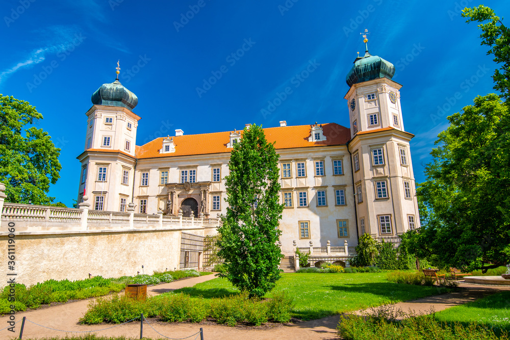 Historical chateau at Mnisek pod Brdy city, Czech Republic. View of ancient building with towers, built in gothic style. Sunny summer day, blue sky and vibrant colors.