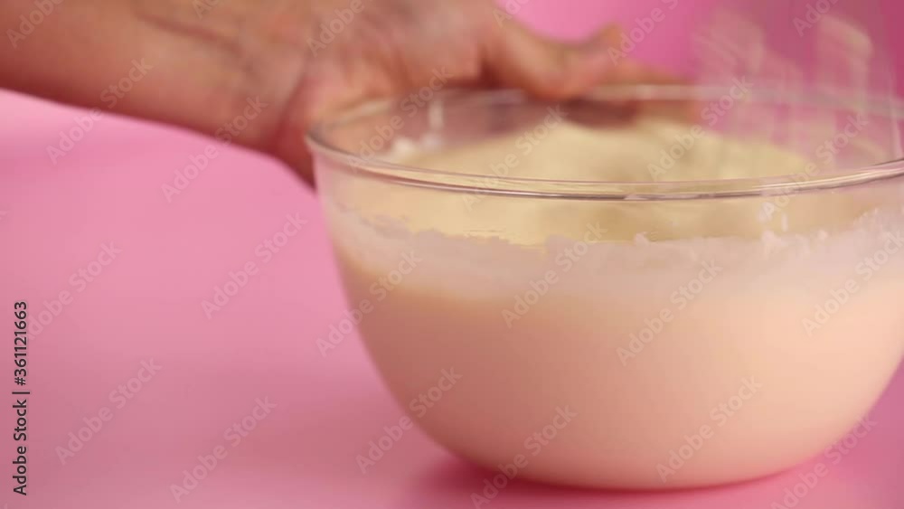 Mixing cream cheese, sugar eggs and vanilla in a glass bowl for a cheesecake Mixing cream cheese, sugar eggs and vanilla in a glass bowl for a cheesecake