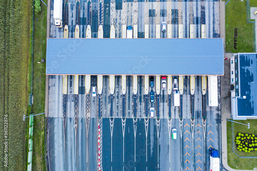 Car traffic transportation on multiple lanes highway road and toll collection gate, drone aerial top view. Commuter transport, city life concept.A2 Poland Lodz