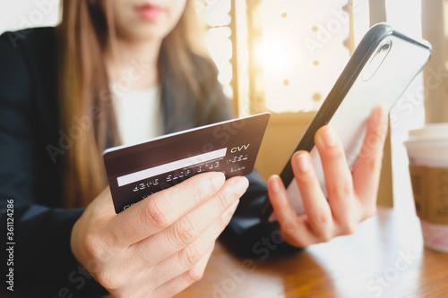 Blur of the online payment,wonan's hands holding a credit card and using smart phone for online shopping. photo