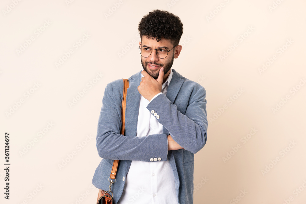 Young business Moroccan man isolated on beige background looking to the side Young business Moroccan man isolated on beige background looking to the side