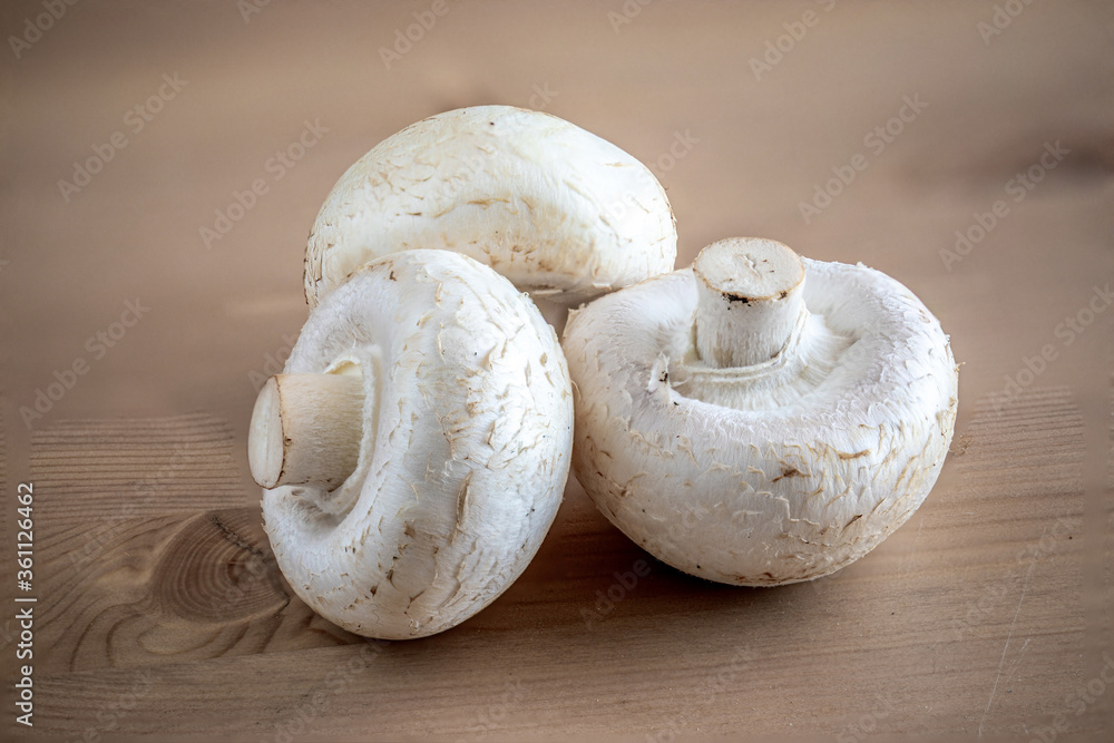 Fresh champignon mushrooms on wooden table, closeup. Organic champignons top view. Copy space