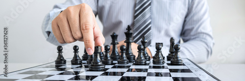 Businessman playing chess and thinking strategy about crash overthrow the opposite team