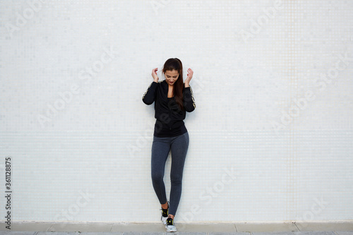 Full length portrait of an attractive and sporty young woman standing against a white background while getting ready for workout outdoors, charming girl with fitness body
