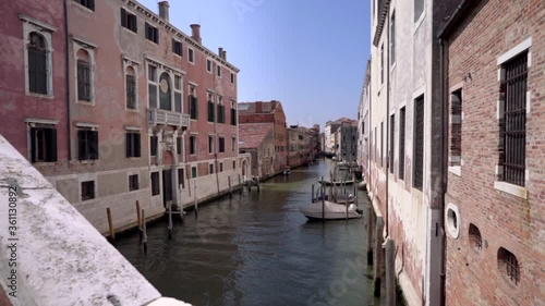 Wallpaper Mural Boats float on one of the many back canals in Venice in Italy surrounded by old colorful traditional buildings while tourists roam the narrow streets.
 Italy, Europe Torontodigital.ca