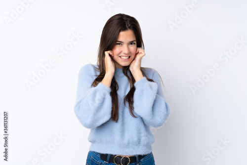 Teenager girl over isolated white background frustrated and covering ears © luismolinero