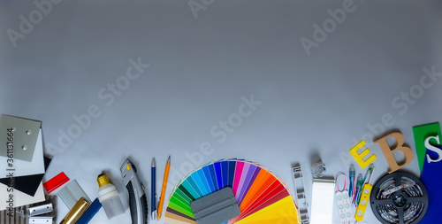 Advertising mattrials and samples on silver background. Colour palette, plastic and metal samples, tools, lighting components.