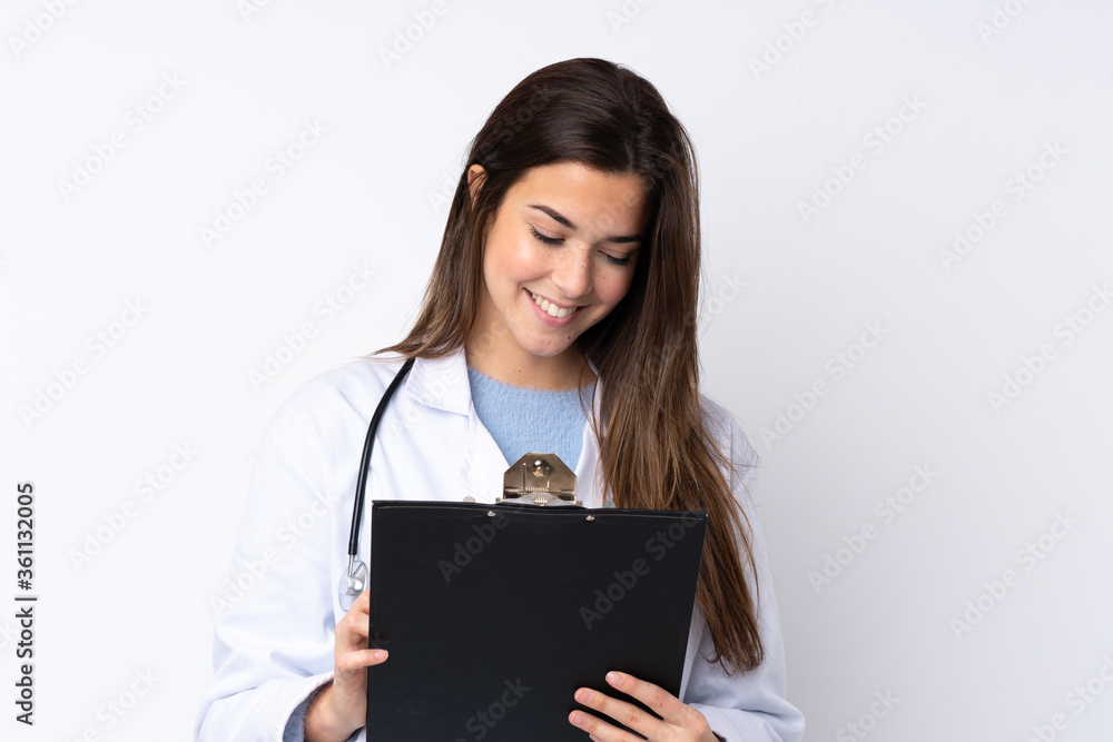 Teenager girl over isolated white background wearing a doctor gown and holding a folder Teenager girl over isolated white background wearing a doctor gown and holding a folder