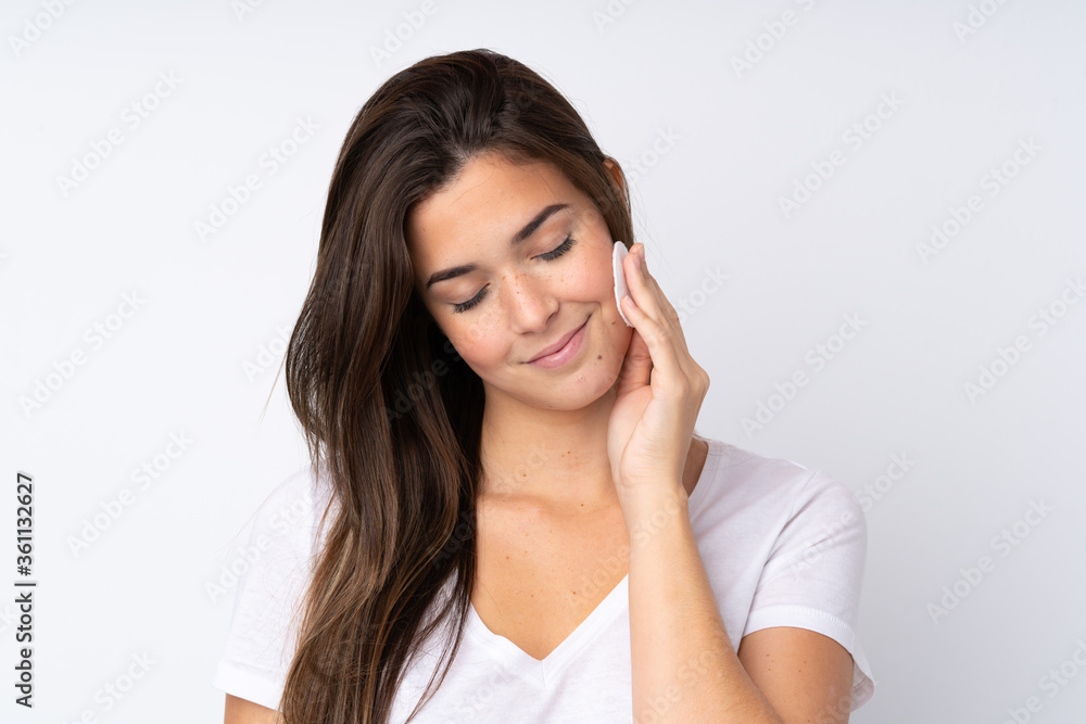 Teenager girl over isolated background with cotton pad for removing makeup from her face Teenager girl over isolated background with cotton pad for removing makeup from her face