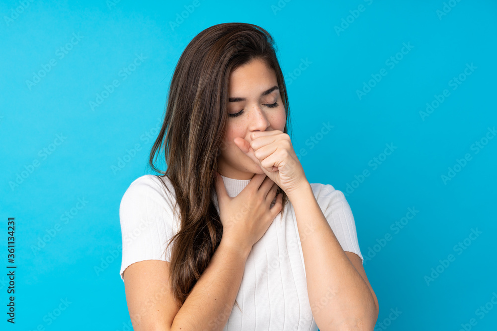 Teenager girl over isolated blue background is suffering with cough and feeling bad Teenager girl over isolated blue background is suffering with cough and feeling bad