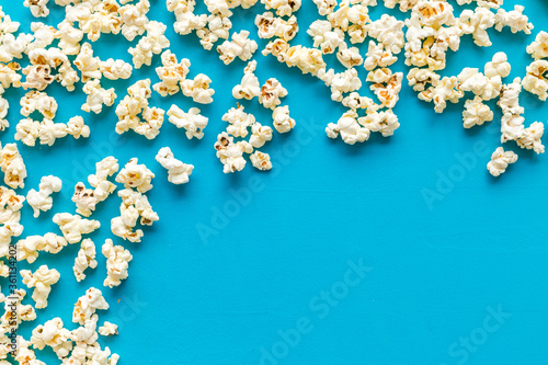 Popcorn frame on blue background top view copy space