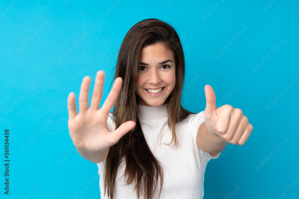 Teenager girl over isolated blue background counting six with fingers Teenager girl over isolated blue background counting six with fingers