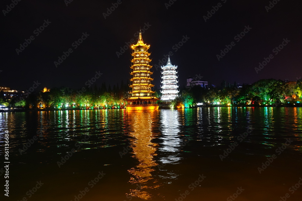 View of traditional pagodas at night reflected in the water